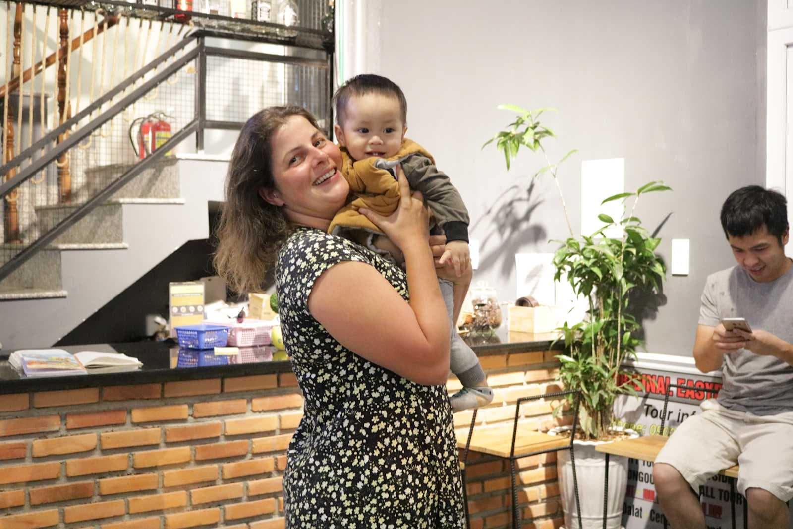 The host holding her baby at reception of Mooka's Home
