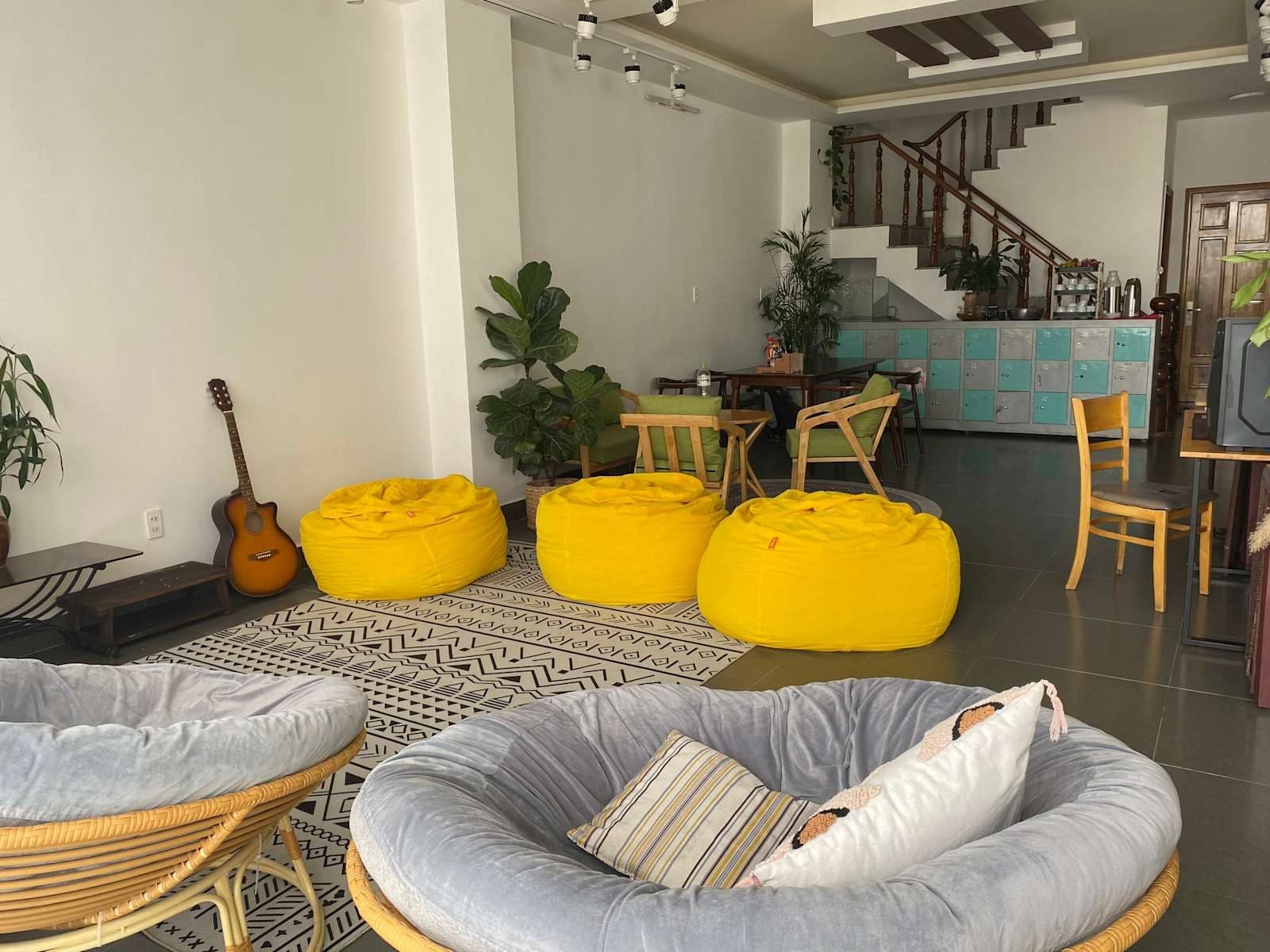 Yellow beanbags, plants and a guitar in the Mooka's Home lounge