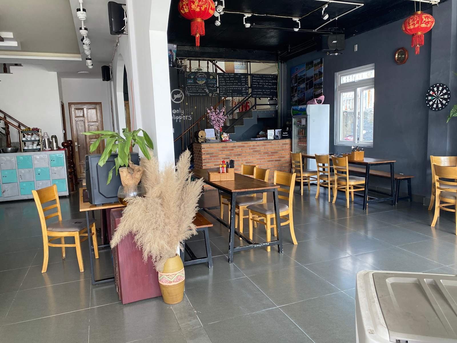 The ground-floor reception and café at Mooka's Home, with the brick counter, wooden tables and lockers, where you check in or leave your bags